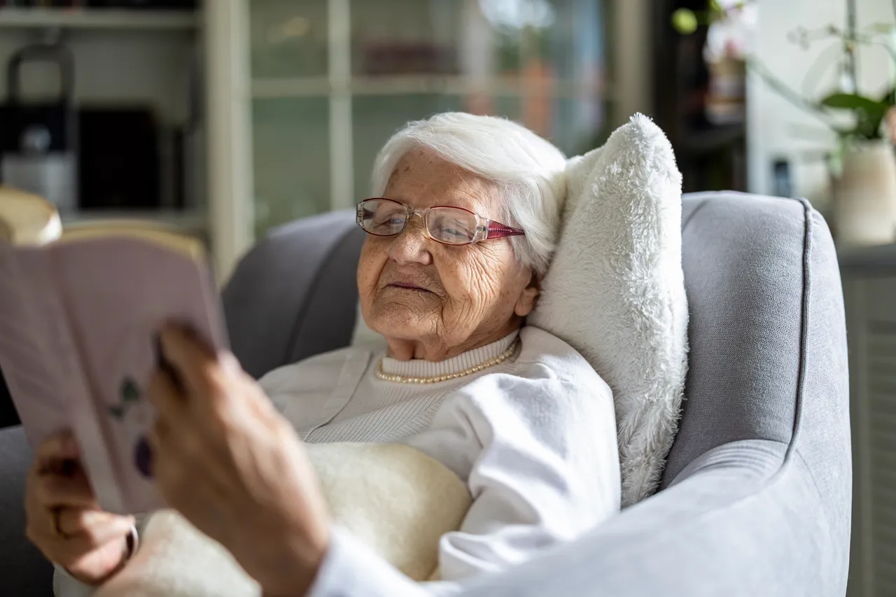 Senior woman reading a book at home peacefully